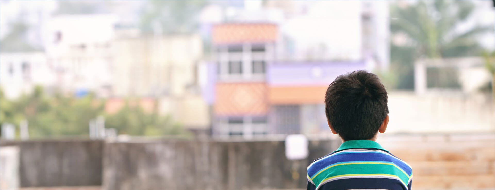 Child sits on a wall as he considers child abuse and neglect