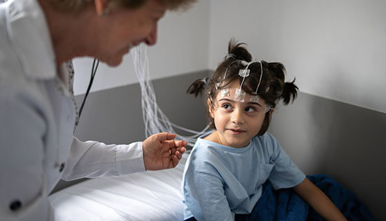 Young child listening to doctor during EEG test