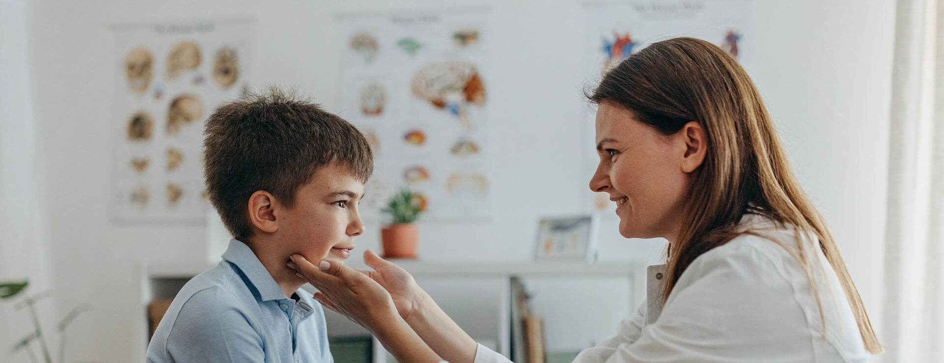 A doctor observes the face of a young patient