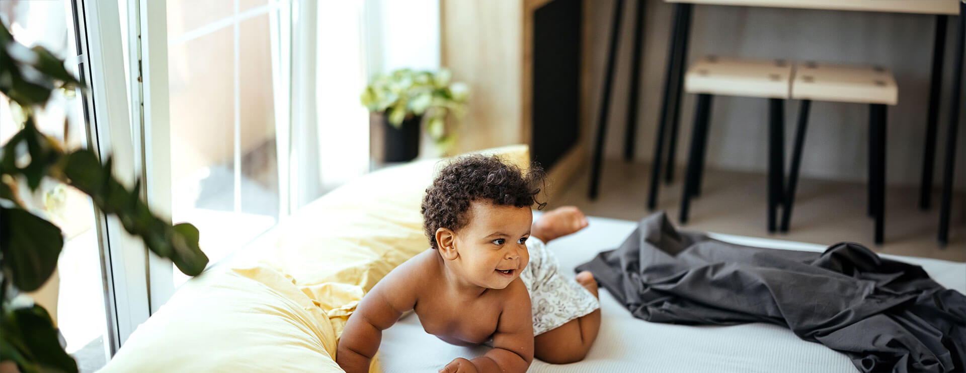 A baby boy plays on the bed after hydrocele repair