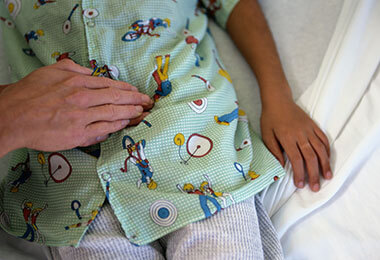 doctor examines a child with an inguinal hernia