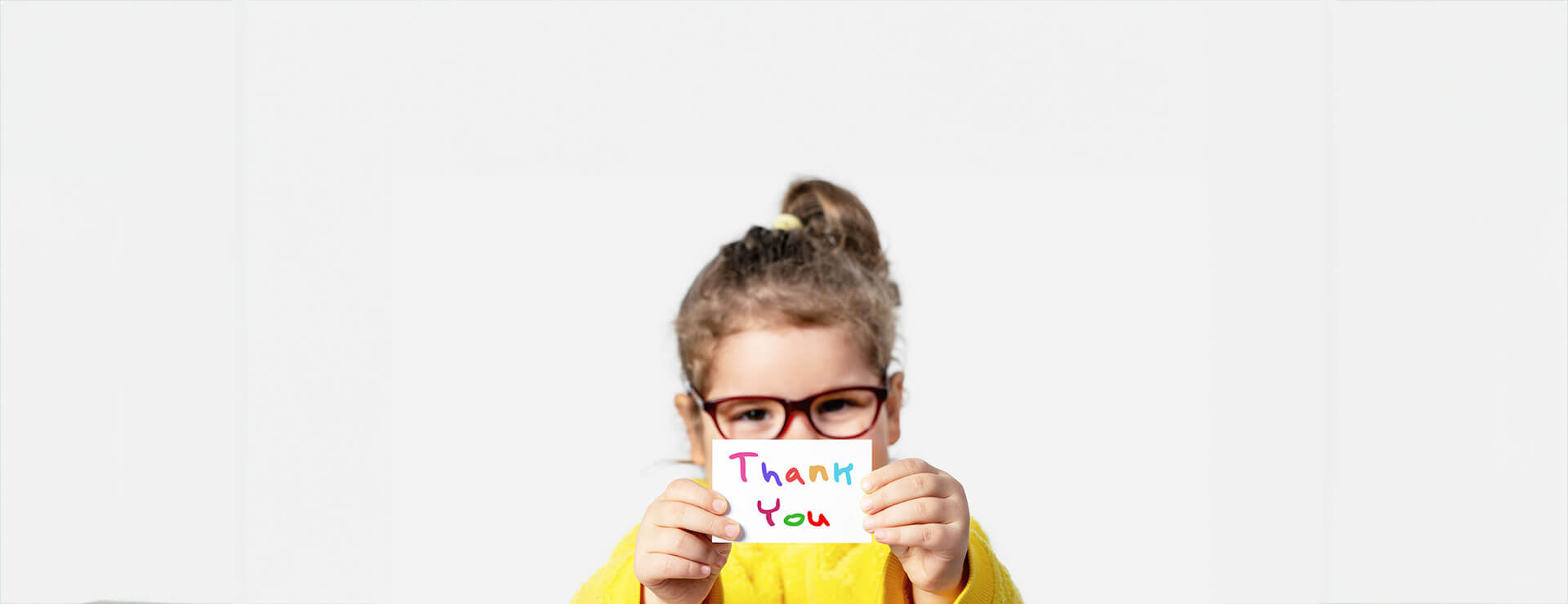 A child holds a card saying thank you