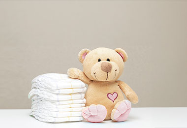teddy bear next to a stack of diapers