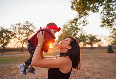a mother holds her infant in the air after tracheomalacia