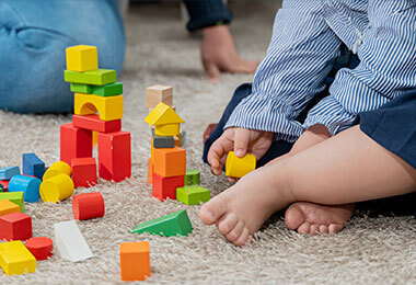 A baby with turner syndrome plays with blocks