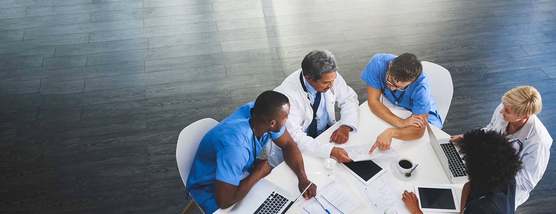 A multidisciplinary team sit around a table, discussing a patient's treatment options.