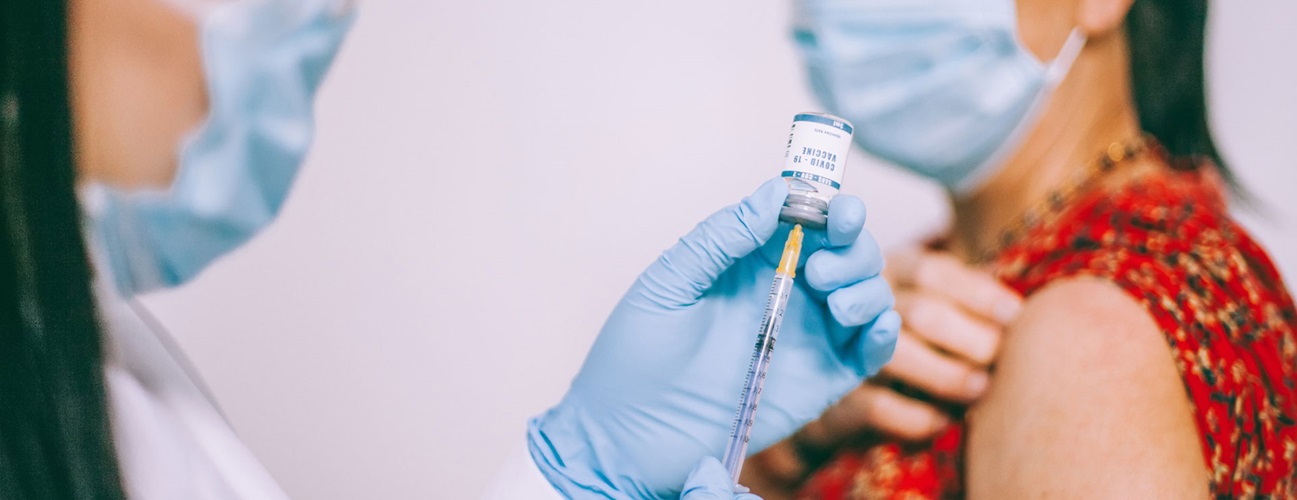 a health care provider prepares a vaccine for a mature woman