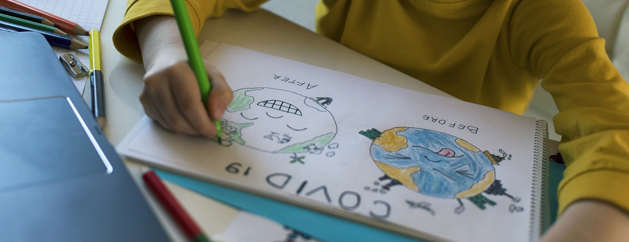 A child colors a drawing depicting a sick earth and a healthy earth.