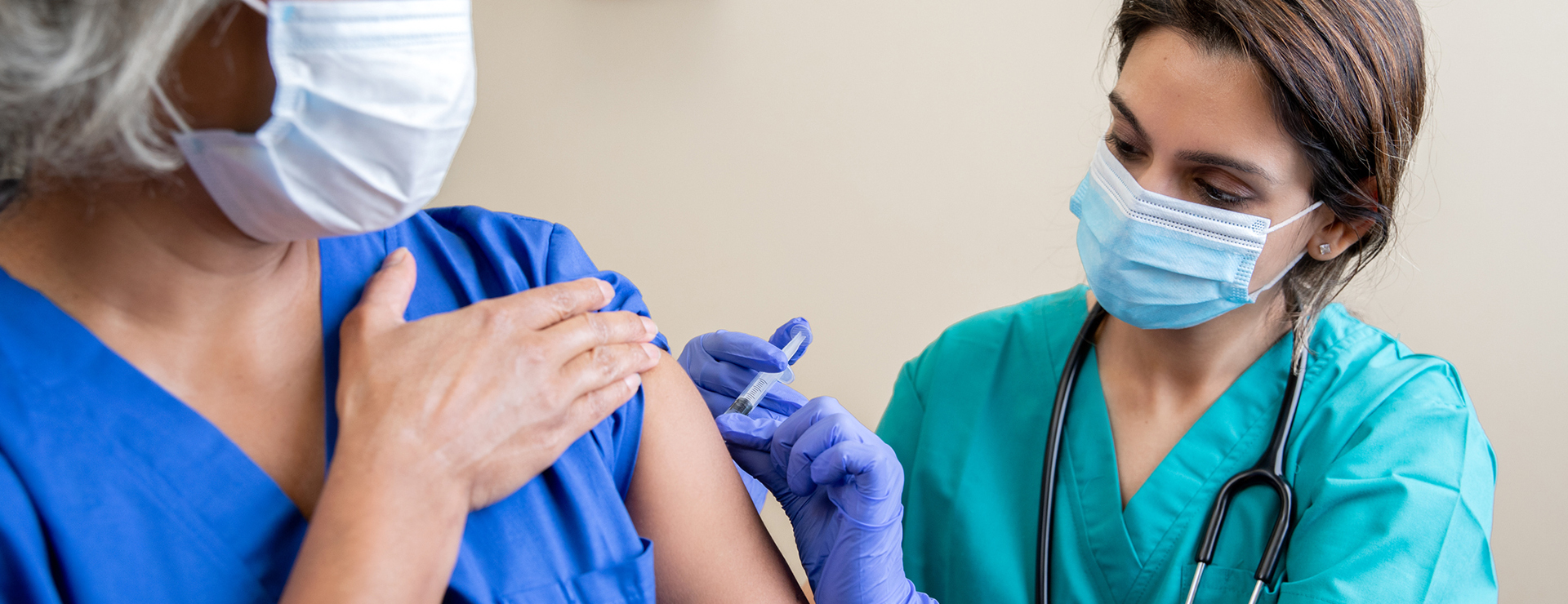 full fda approval of a COVID19 Vaccine - healthcare provider administering needle to mature woman