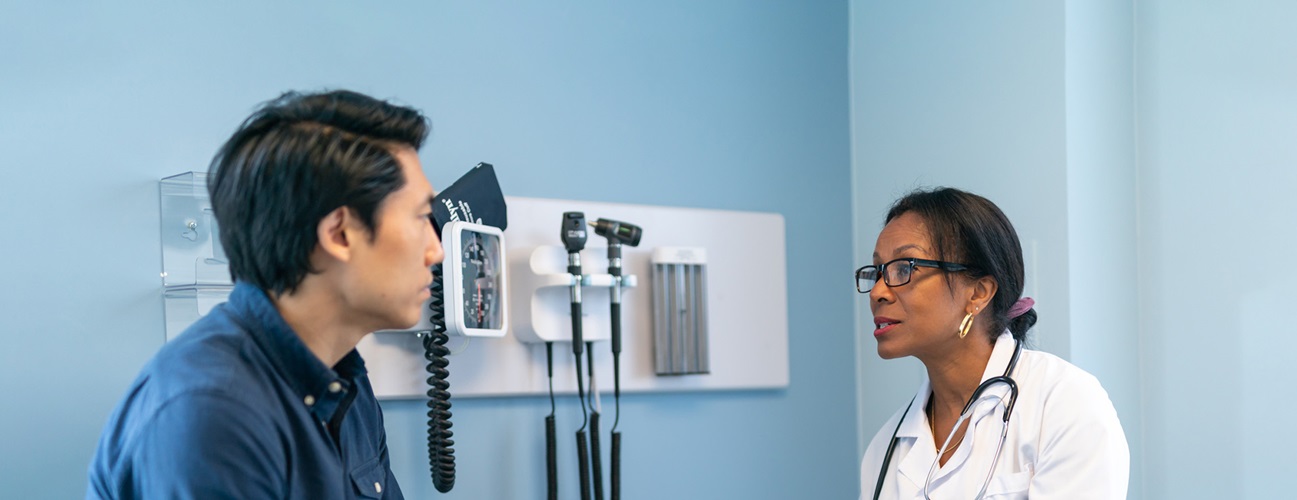 An adult male patient speaks with his doctor.