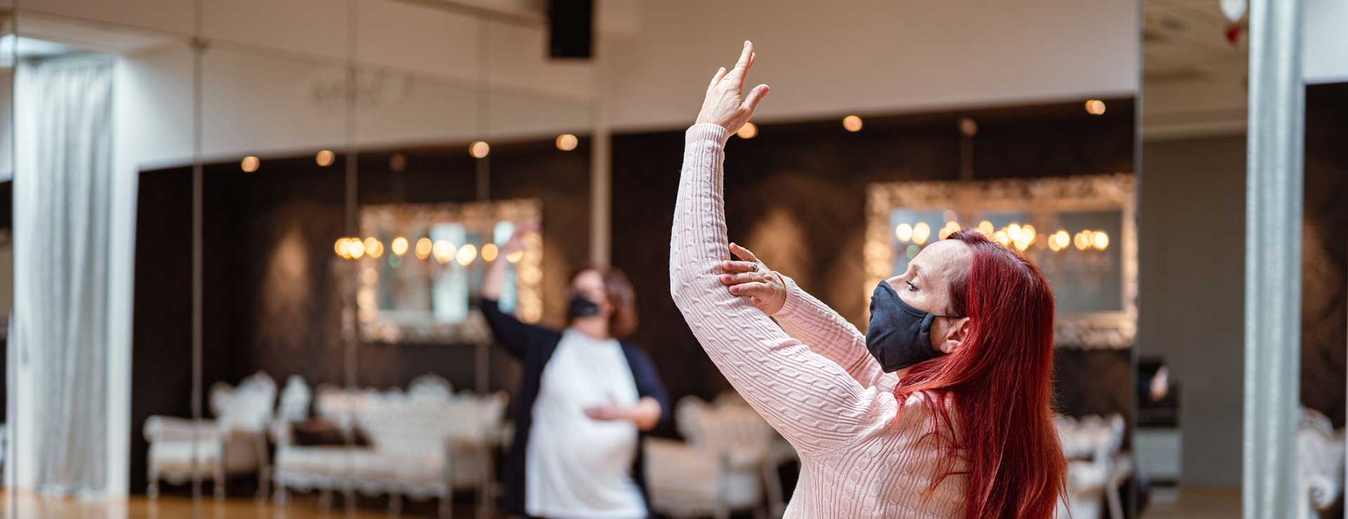 Dance instructor wearing a mask and teaching a class.