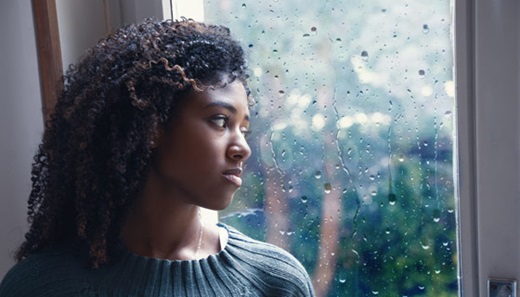 Depressed woman looking out a window