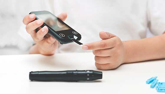 Young boy using a glucometer.