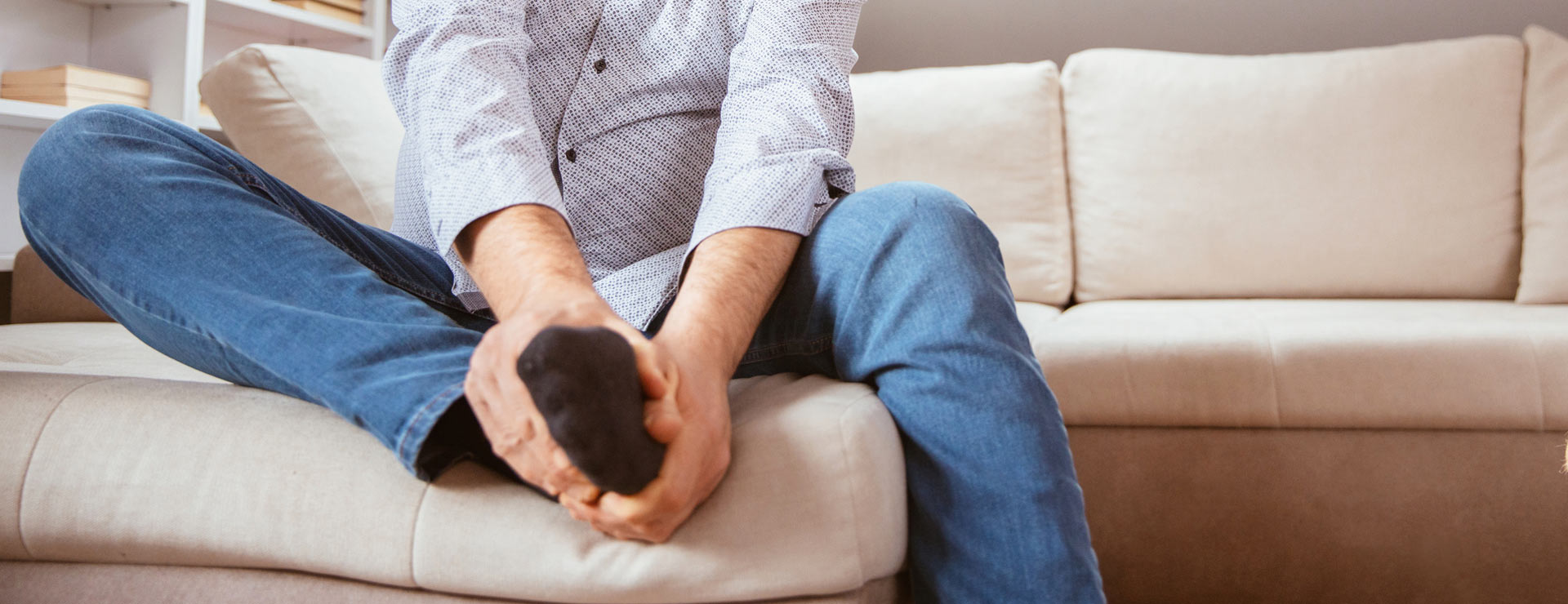 Man with gangrene holding his foot in pain