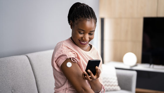 Woman testing with continuous glucose monitor