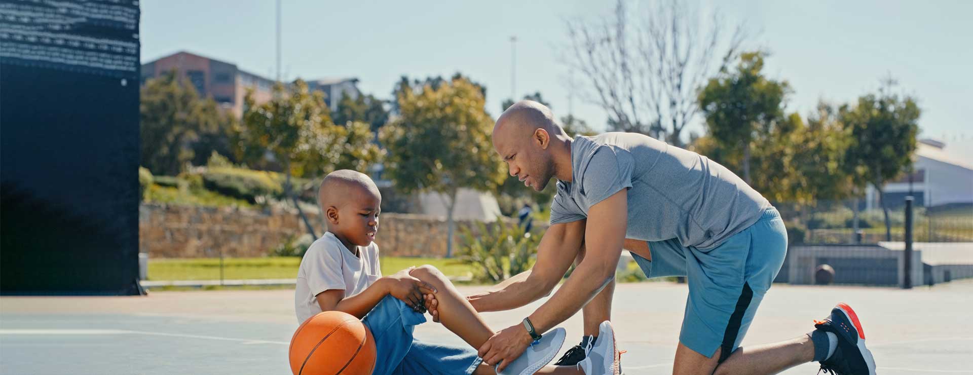 Man holding son's knee after sports injury