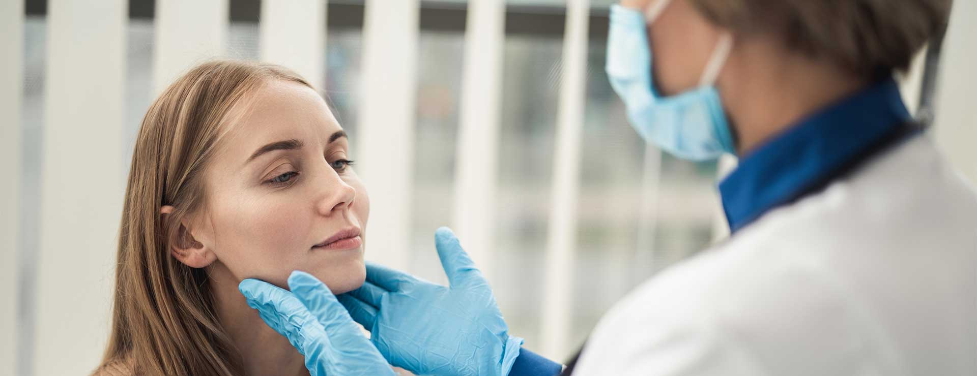 doctor inspecting woman's throat 