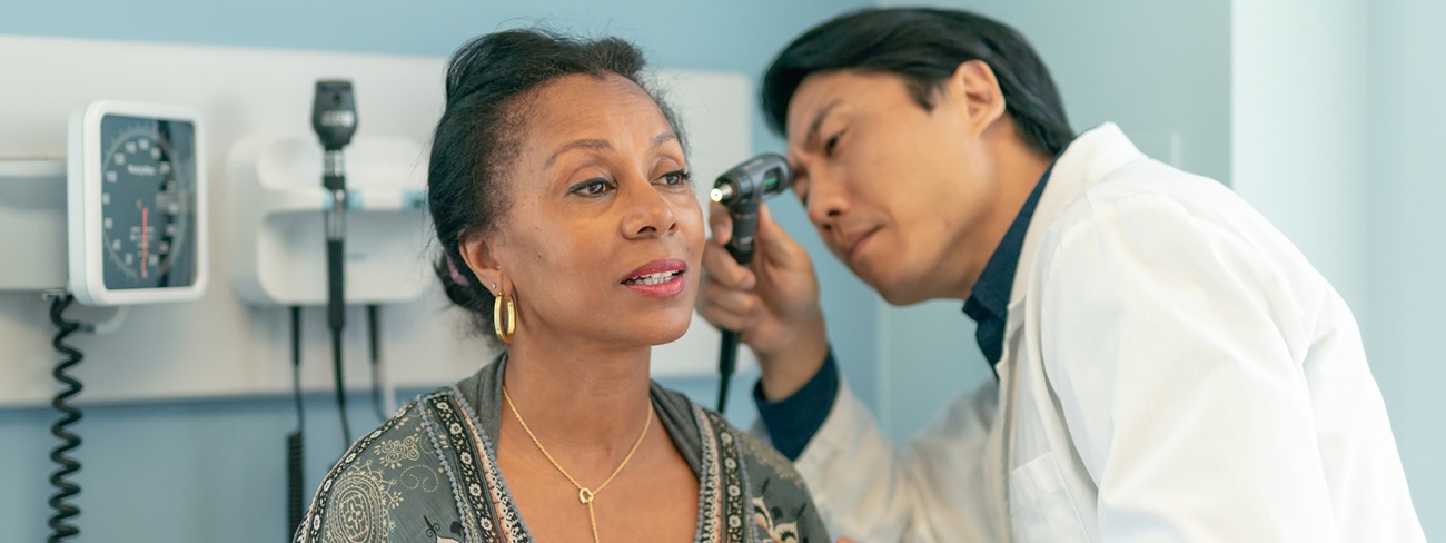 doctor examining female patients ear