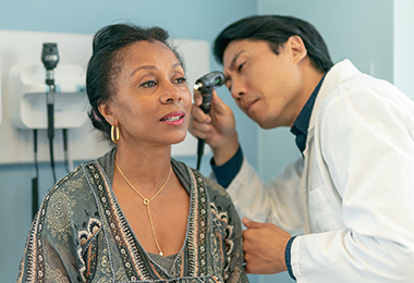 doctor examining female patients ear