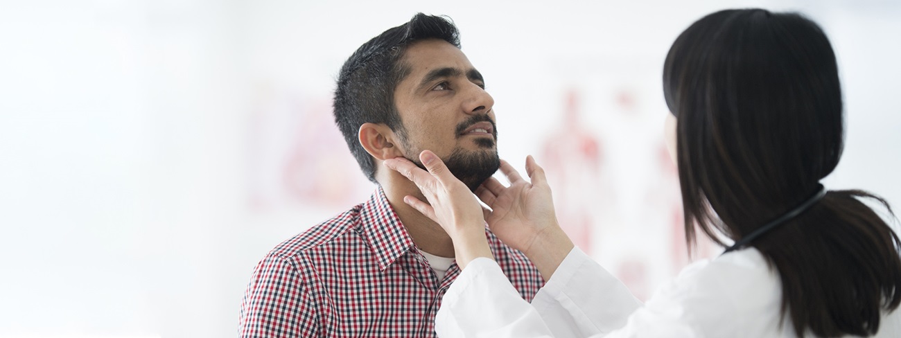 doctor checking male patients neck