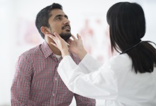 doctor checking male patients neck