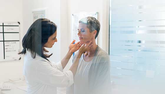 Doctor examines a woman's neck
