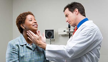 doctor checking thyroid glands of female patient