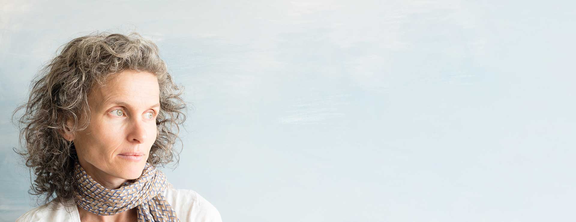 A middle-aged woman looks off into the distance.