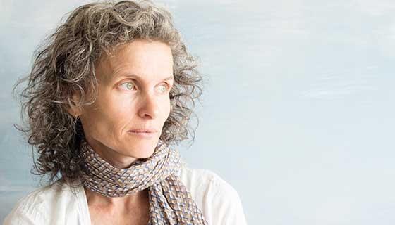 A middle-aged woman looks off into the distance.