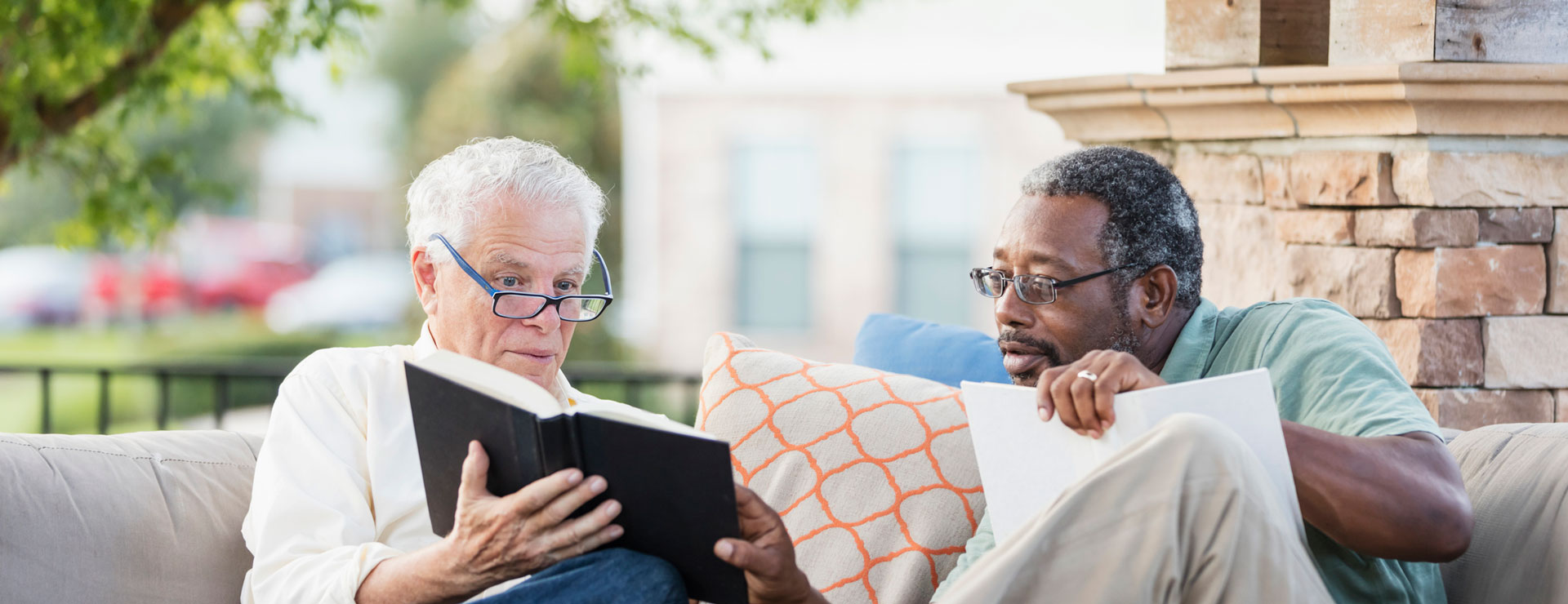 two elder men reading outside