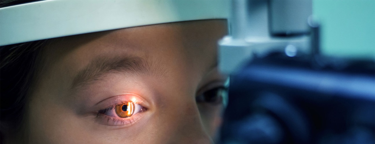 A close up of a child during a slit-lamp eye exam.