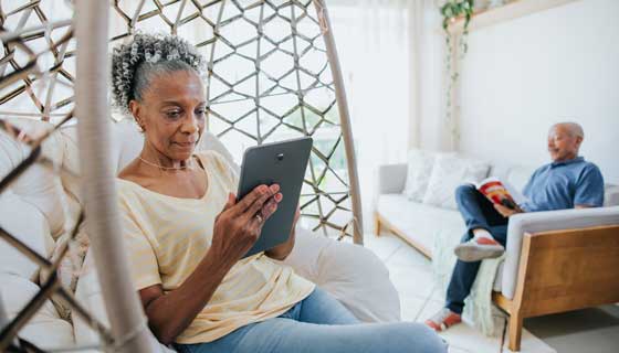 An elder couple in the living room reading separately