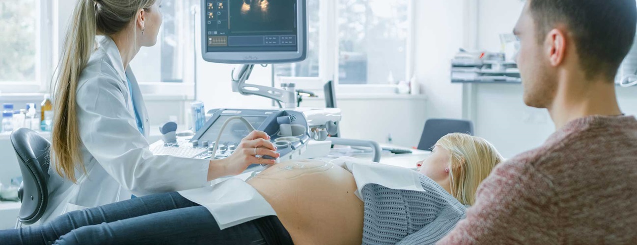 Doctor using a sonogram machine on a pregnant patient