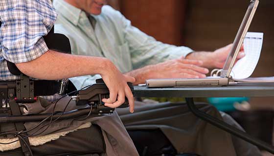 business man in wheelchair at laptop
