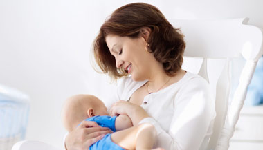 Breastfeeding mother with baby in their nursery