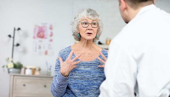 Senior woman talks to male doctor in clinic