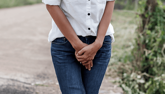 woman holds hands over pelvis