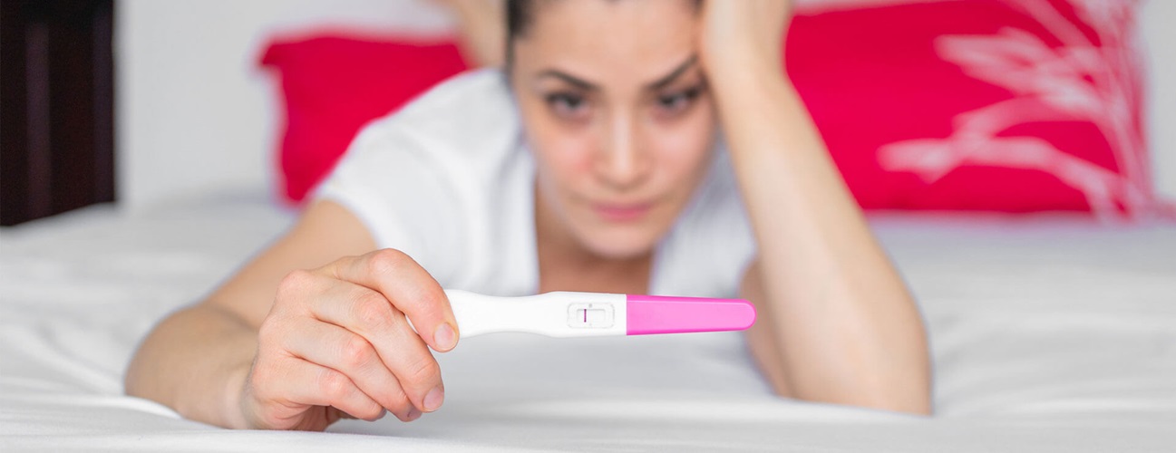 woman holds negative pregnancy test