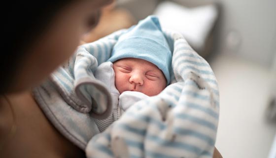 Mother with her bundled up newborn