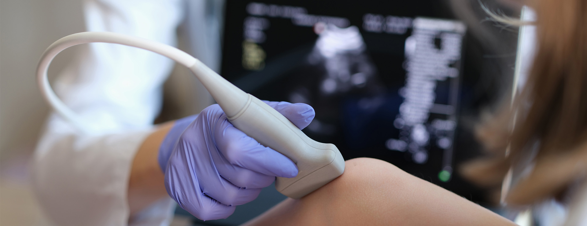 A doctor conducts an ultrasound examination on the leg of a child.