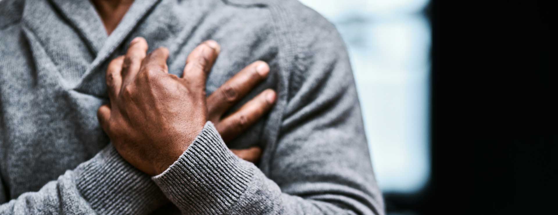 A man clutches his chest in pain.