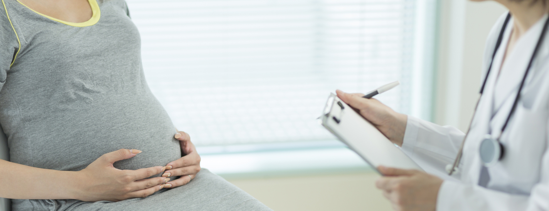 peripartum cardiomyopathy - woman holding belly at doctor's office
