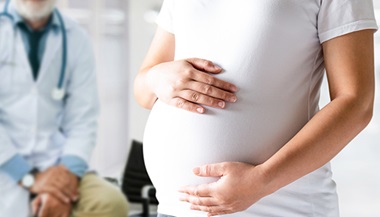 Peripartum cardiomyopathy - pregnant woman holding belly at doctor's office