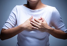 Woman holding her hands over her heart