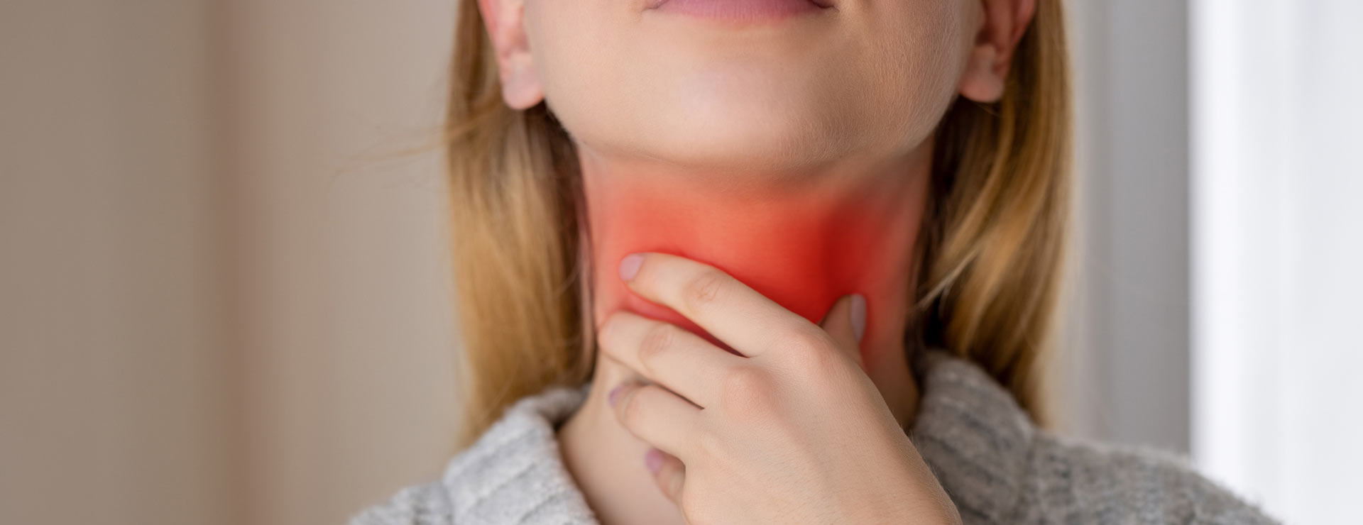 Woman holding her throat in pain