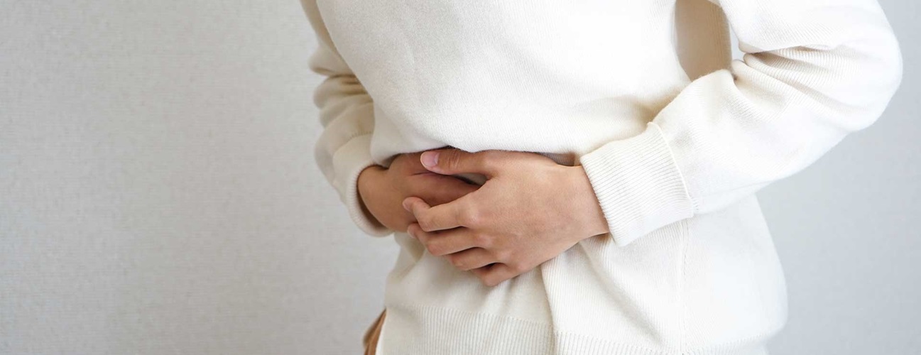 Woman clutching her stomach in pain.