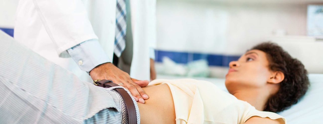 woman receiving abdomen exam from doctor