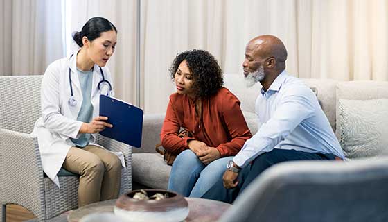 Doctor speaks with a father and his adult daughter.