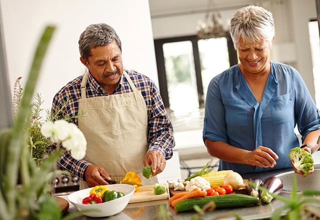 Couple prepares produce on the kitchen counter