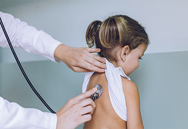 Doctor checking child's breathing. 